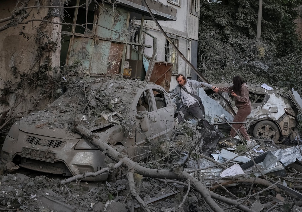 Residents near an apartment building damaged during a Russian drone and missile strike in Kyiv (Reuters)