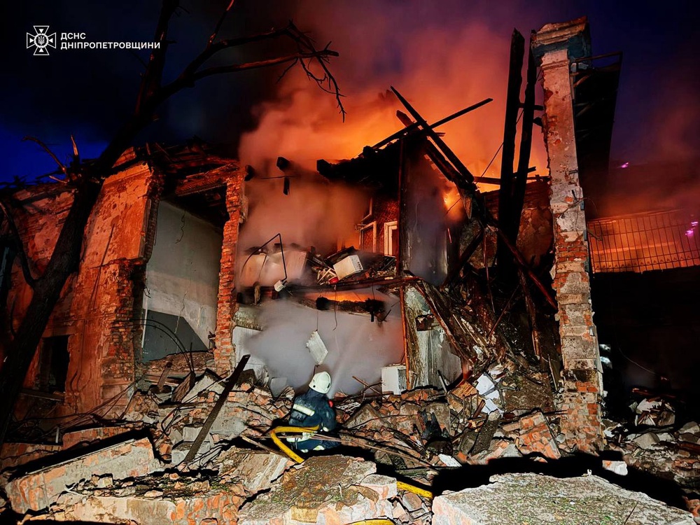 A rescue worker puts out a fire of a residential building destroyed after a Russian strike on Dnipropetrovsk region, on 2 June (Ukrainian Emergency Service)
