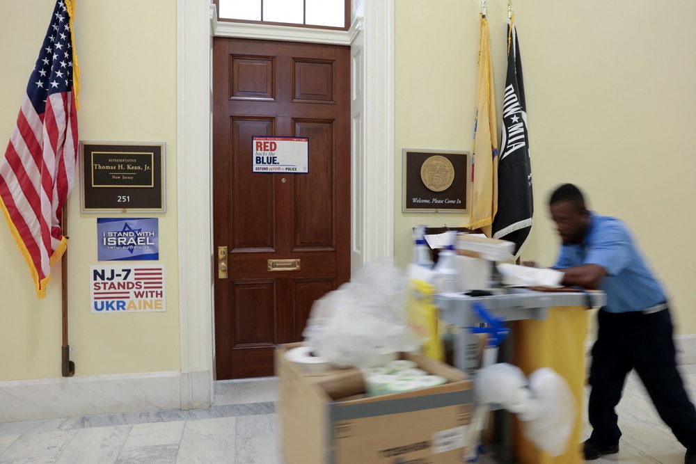 A worker passing by Rep. Kean’s office in Washington DC where he has been absent for several months (Reuters)