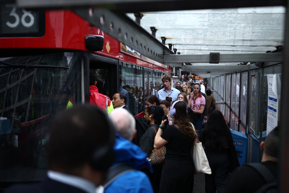 Commuters queue for a red double decker bus outside Victoria train station (AFP/Getty)