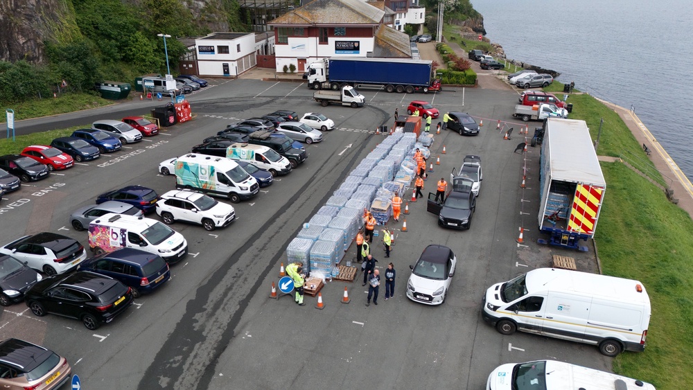 A drone view of people collecting bottled water at Freshwater car park in Brixham (PA) (PA Archive)