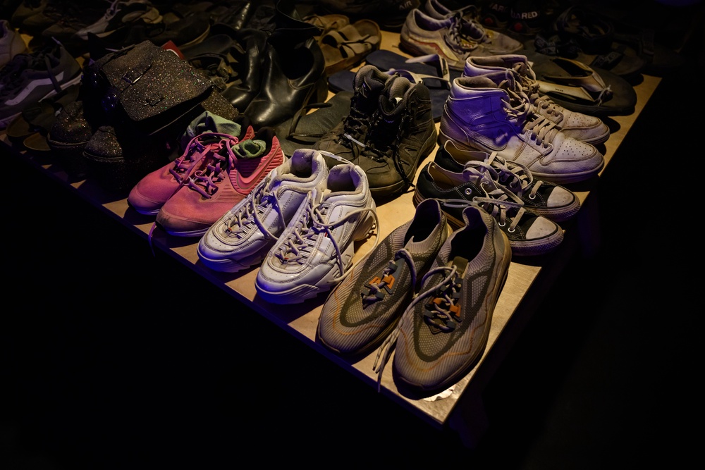 Rows of shoes recovered from the festival site are displayed at the Nova Exhibition, ‘06:29AM – The Moment Music Stood Still’ in London (Getty)