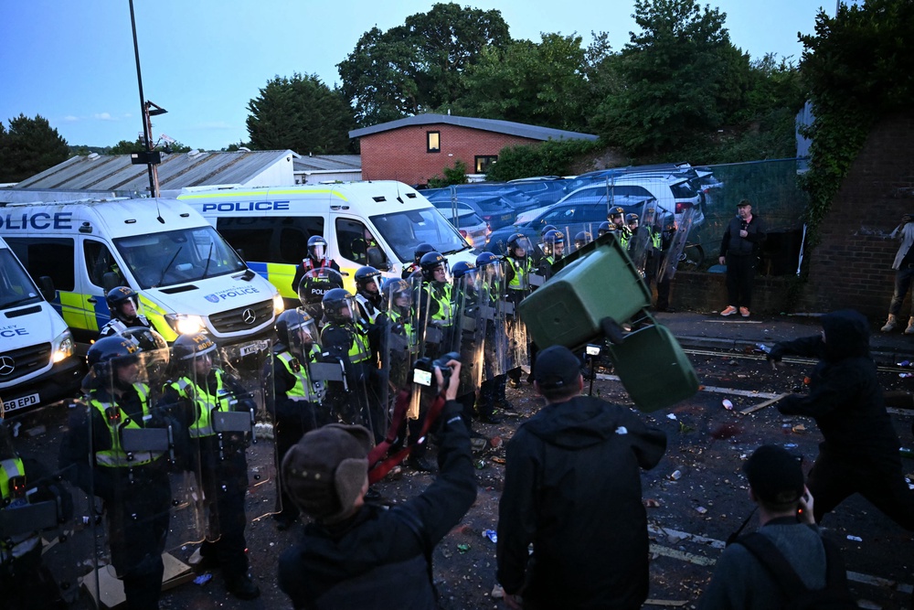 A demonstrator throws a bin at police officers near Portswood Police Station (AFP/Getty)
