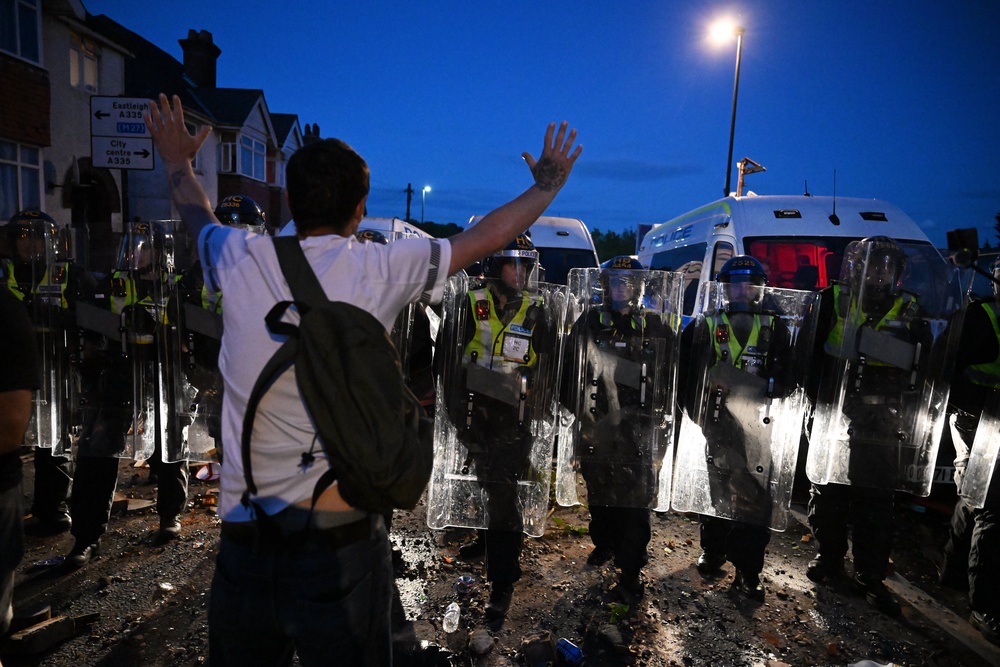 A protestor confronts riot police near the location where Henry Nowak died during a demonstration over the Police's handling of the incident (Getty)