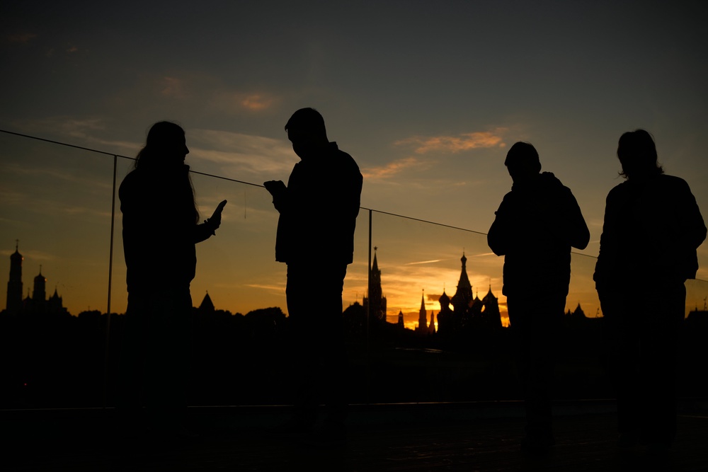 People walk along the Floating Bridge at Zaryadye park during sunset in Moscow (AP)