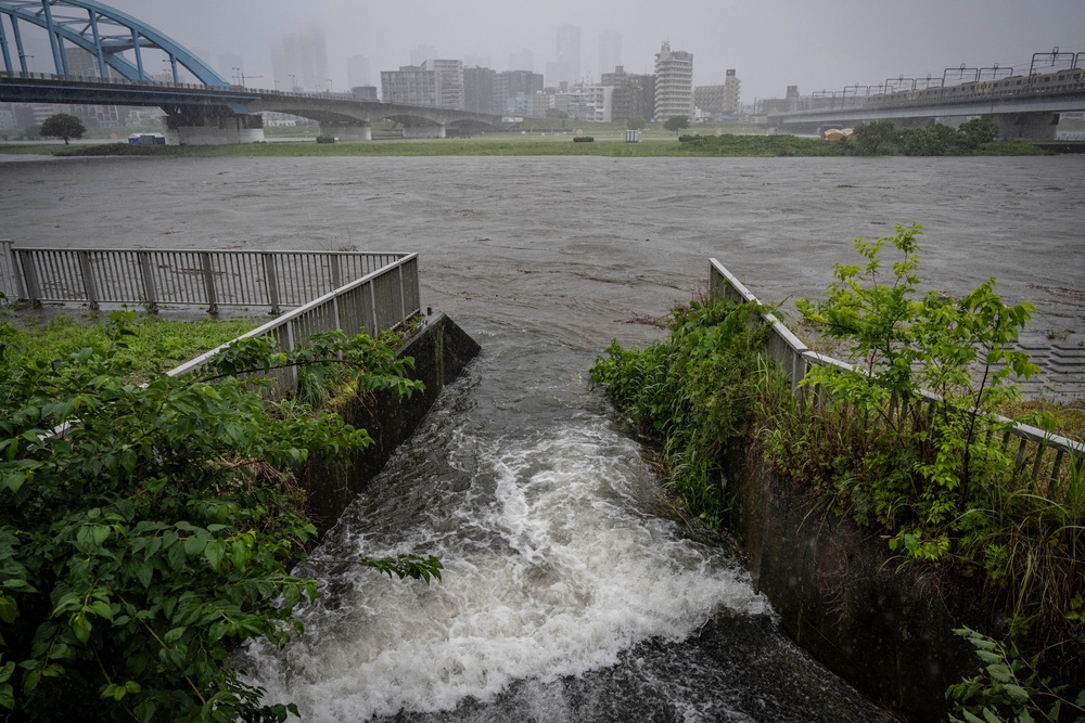 Water flows into the swollen Tama river amid heavy rain brought by severe tropical storm Jangmi in Tokyo on 3 June 2026 (AFP/Getty)