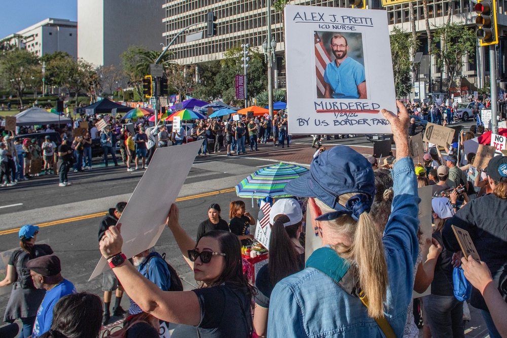 A woman holds a sign with a picture of Alex Pretti, who was killed by ICE agents in Minneapolis, in a protest against immigration in an 