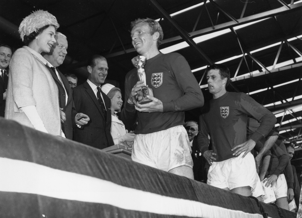 Elizabeth II smiles after presenting Moore with the Jules Rimet trophy (Getty)