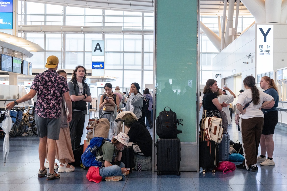 Passengers wait at the international terminal at Haneda airport after flights were cancelled or severely delayed because of severe tropical storm Jangmi in Tokyo on 3 June 2026 (AFP/Getty)