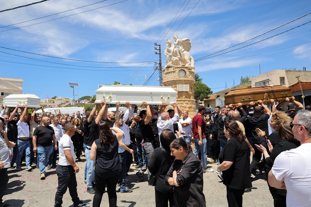 Relatives and friends of a man who was killed along with his son and daughter in an Israeli strike that targeted their car earlier this week in southern Lebanon attend their funeral in the christian border village of Qlayaa (AFP/Getty)