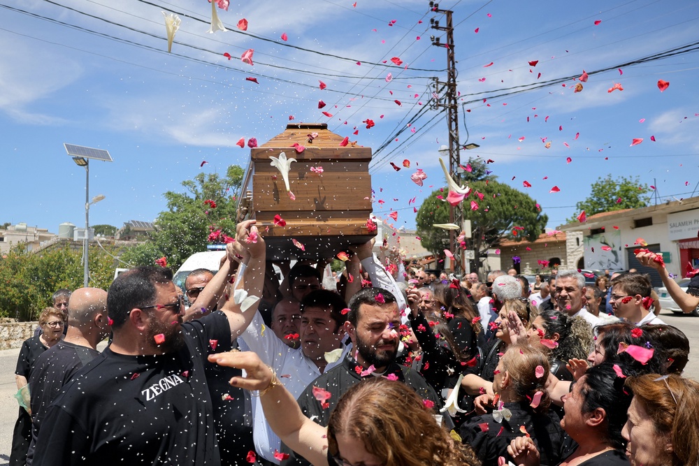 Relatives and friends of a man who was killed along with his son and daughter in an Israeli strike that targeted their car earlier this week in southern Lebanon attend their funeral in the christian border village of Qlayaa (AFP/Getty)
