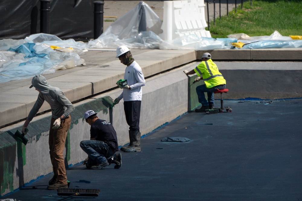Money from national parks passes is paying for a renovation of the Lincoln Memorial Reflecting Pool, where workers are seen applying a blue coating (AP)