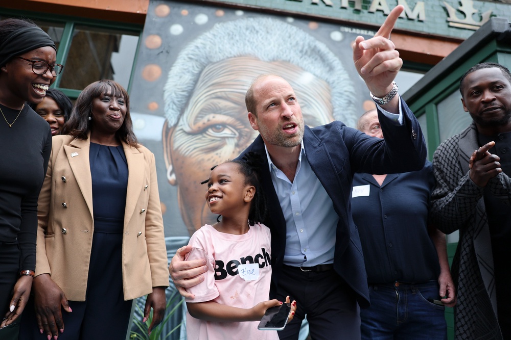 The Prince of Wales hugs a young child during a visit to the Prince of Peckham Pub in London (Chris Jackson/PA) (PA Wire)