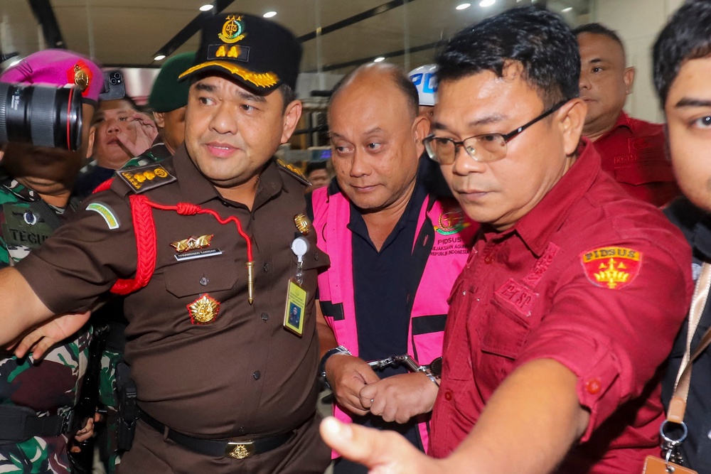 Dadan Hindayana (C), former head of Indonesia's free school meals programme, is escorted by officers from the Attorney General's Office and Indonesian military personnel as he leaves the Attorney General's Office building in Jakarta on 3 June 2026, following questioning over alleged misappropriation in the implementation of the programme (AFP/Getty)