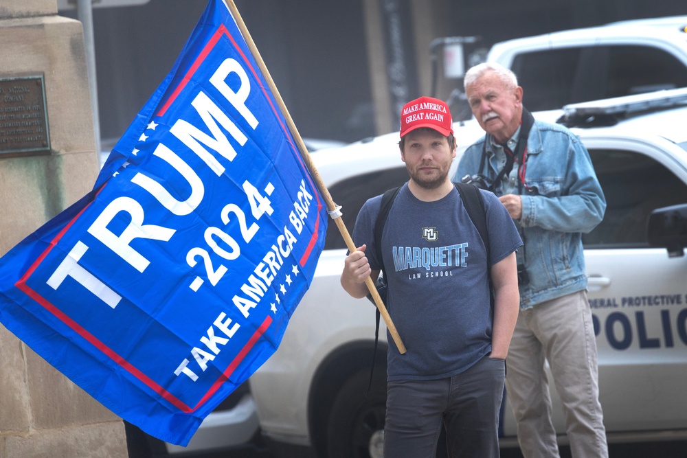 A supporter of President Donald Trump stands across the street as supporters of Milwaukee County Circuit Judge Hannah Dugan demonstrate outside of the Milwaukee Federal Courthouse while she was scheduled to appear in court on May 15 (Getty)