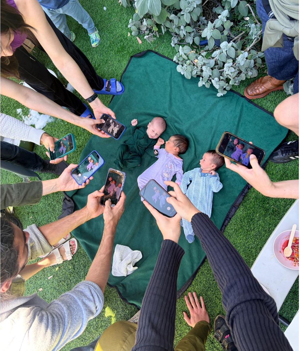 When three infants were born within a 15-day window, the entire 20-person community surrounded them on a blanket for a celebratory ‘paparazzi’ shot (Phil Levin)