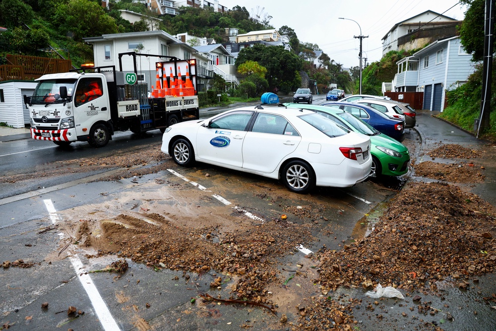 File: Road workers drive past a slip in the suburb of Brooklyn during a bout of severe weather in April (Getty)