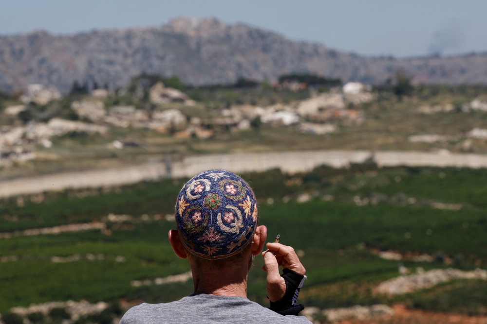 An Israeli man stands against the backdrop of southern Lebanon, along the Israel-Lebanon border (AFP/Getty)