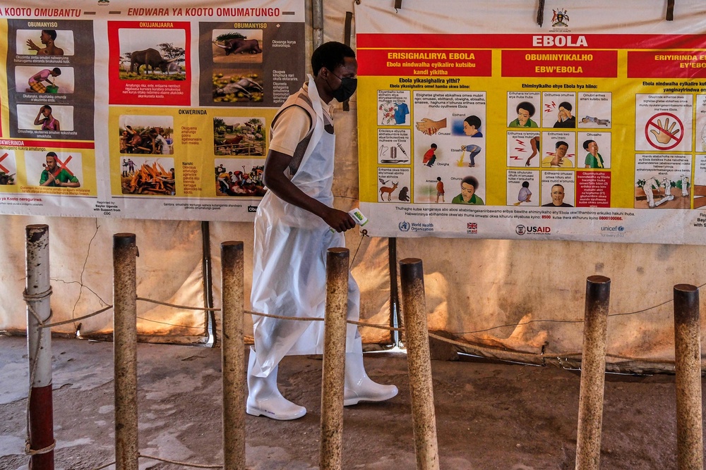 A health worker walks past Ebola warning and instruction posters at a temporary health clinic at the Mpondwe border crossing linking Uganda and the Democratic Republic of the Congo, Thursday, June 4, 2026. (AP Photo/Hajarah Nalwadda) (Copyright 2026 The Associated Press. All rights reserved)