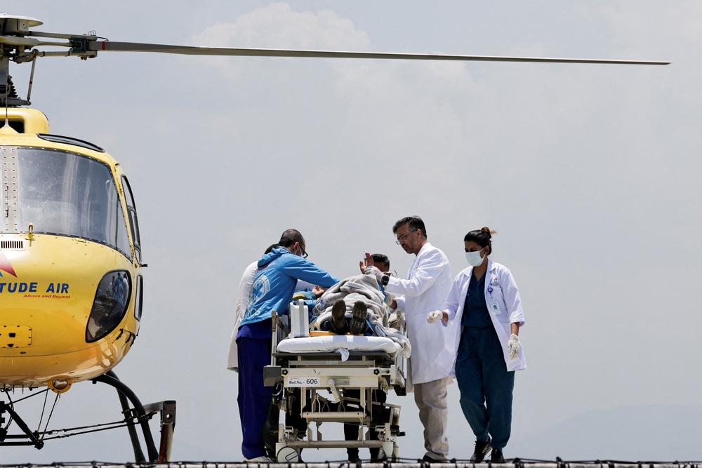 Paramedics work to transport Dawa Sherpa, who was missing for several days in the Everest region, from the helipad at HAMS Hospital in Kathmandu, Nepal, 4 June 2026 (Reuters)