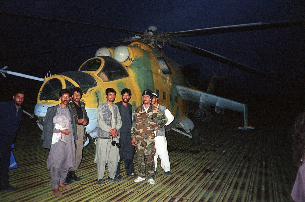 Taliban forces pose in front of a Soviet-made MI-24 helicopter gunship at Bagram military air base in 1996 (AFP/Getty)