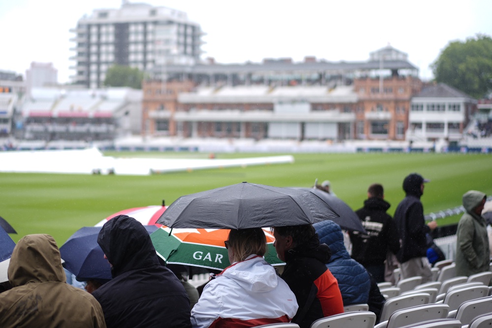 Spectators shelter from the rain at Lord’s (Ben Whitley/PA). (PA Wire)