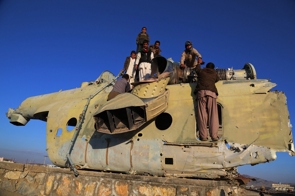 Afghan children play over the wreckage of an old Soviet-era helicopter in Ghazni (AFP/Getty)