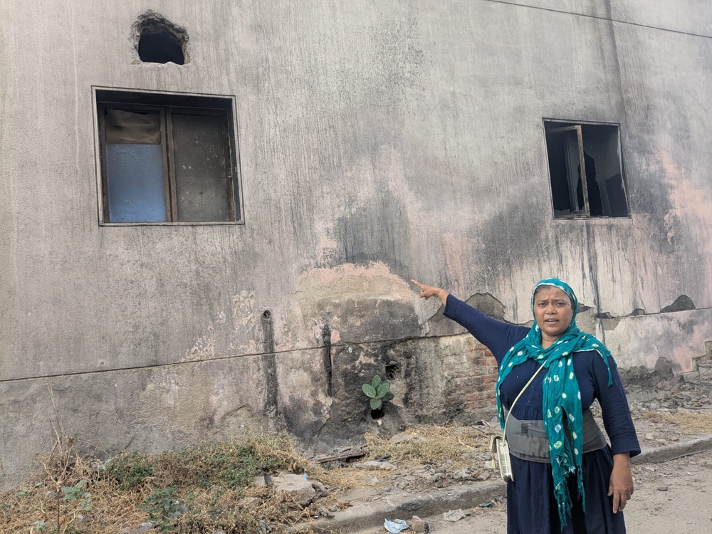 Gitaben Patel shows the window from which she jumped after the crash to escape injuries (The Independent)
