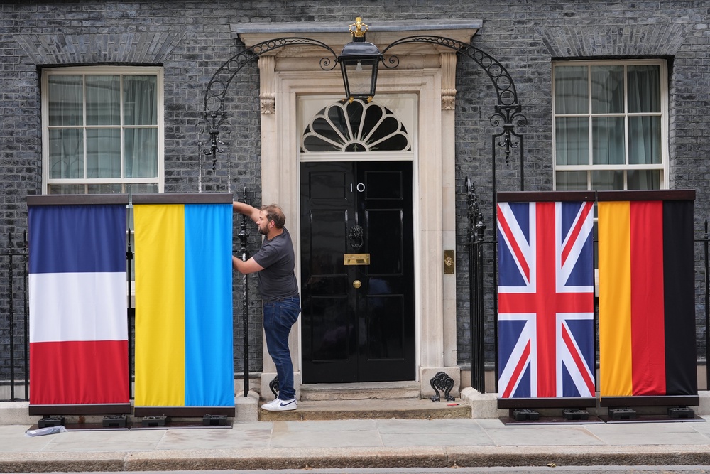 A worker prepares the flags of ((eft to right) France, Ukraine, United Kingdom and Germany, at the door of No 10 Downing Street (PA)