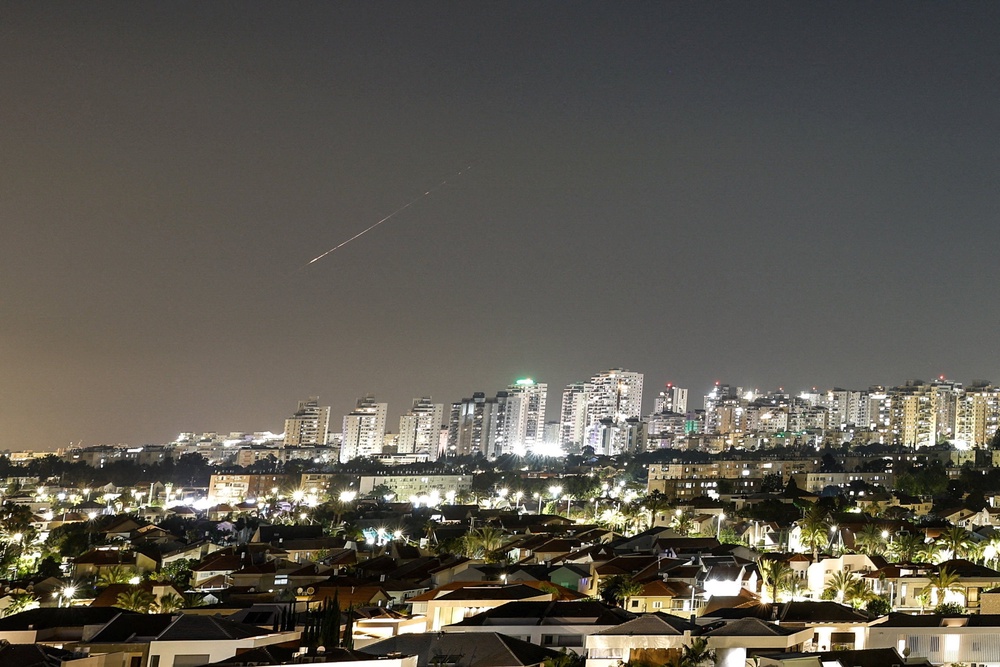 A streak of light illuminates the sky during a missile attack from Iran towards Israel as seen from Ashkelon, Israel, June 7 (Reuters)