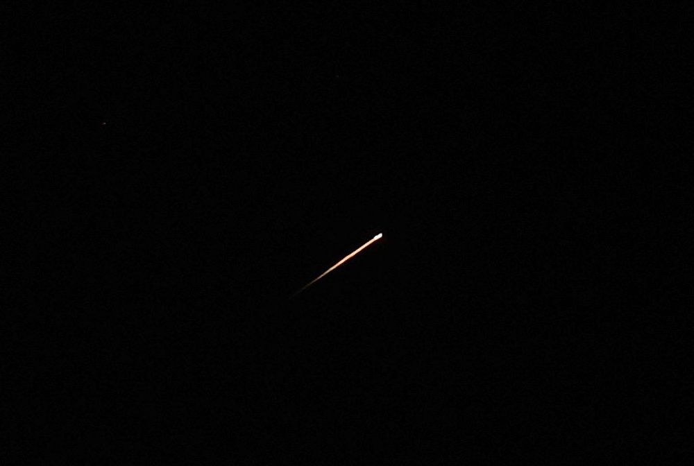 A streak of light illuminates the sky during a missile attack from Iran towards Israel, as seen from Jerusalem (Reuters)