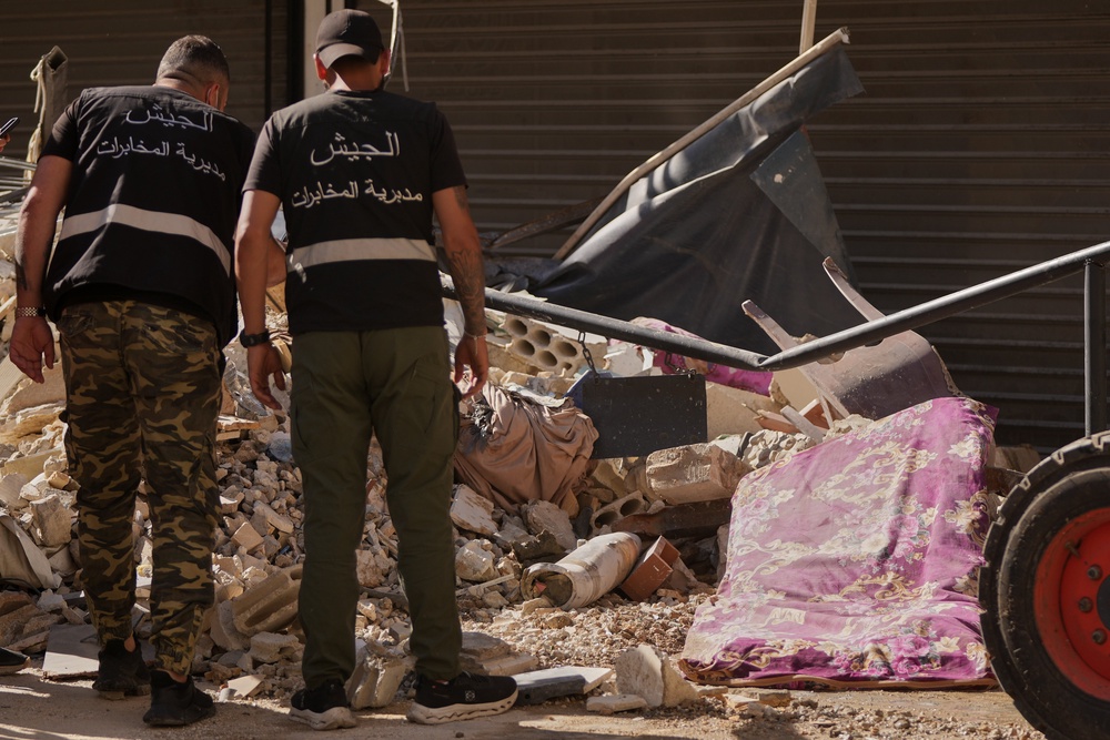 Lebanese intelligence officers look at an unexploded missile, centre, at the site where an Israeli airstrike hit a building in Dahiyeh (Hassan Ammar/AP) (AP)