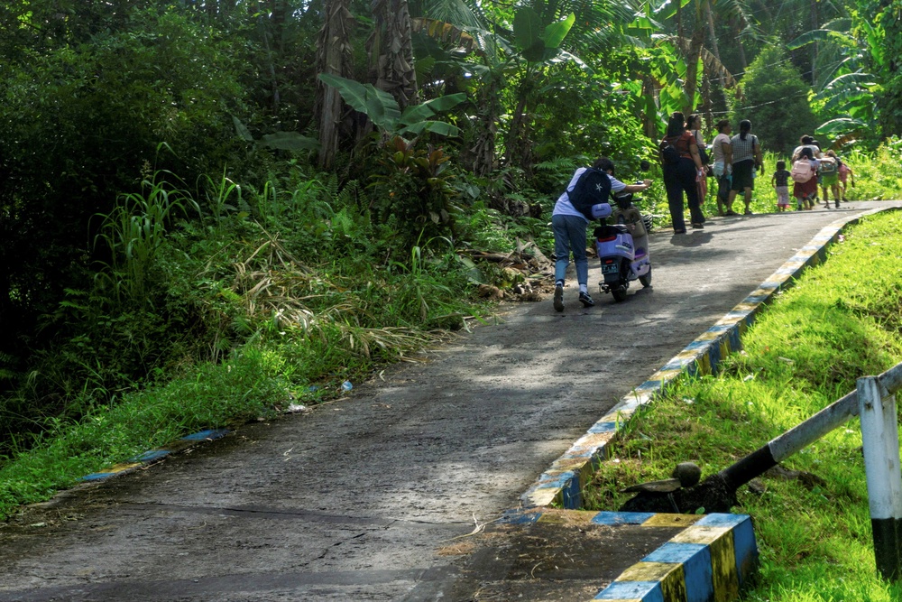 People walk as they evacuate to the highlands after Indonesia’s geophysics agency issued a tsunami warning (Reuters)