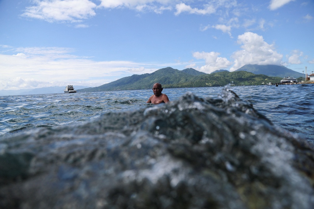 A man swims near Falajawa beach as the Meteorology, Climatology, and Geophysical agency issued a tsunami warning (Reuters)