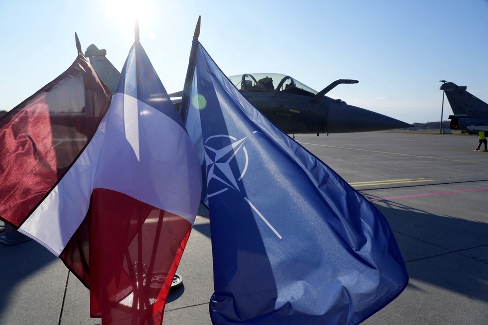 File: Latvian, French and Nato flags flutter in front of a French Rafale fighter jet of the Nato Baltic Air Policing mission in Latvia (Reuters)