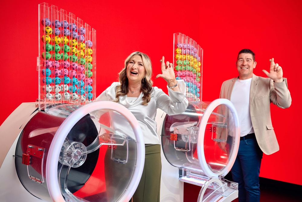 Chris and Geraldine Bradley, who won £3.57M on Lotto in 2006, alongside the two Lotto draw machines to mark the new two-round format (PA)
