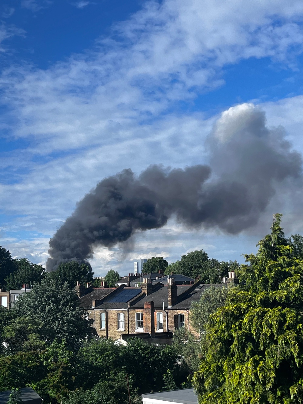 A column of smoke billows over southeast London on Monday afternoon amid a blaze at a recycling plant (Supplied)