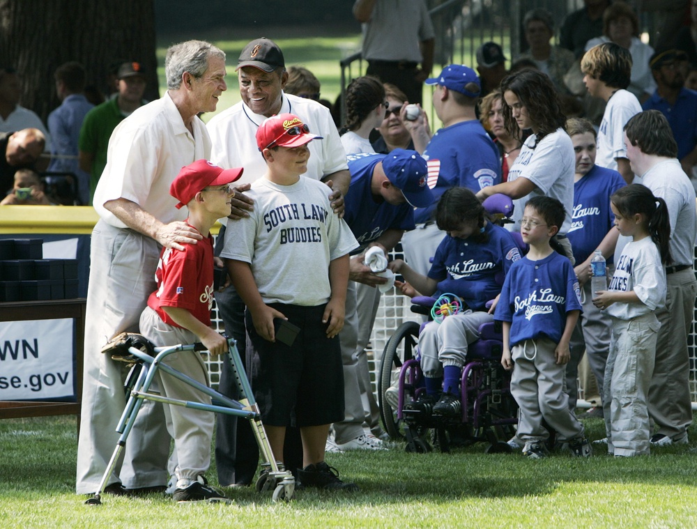 President George W. Bush, left, and National Baseball Hall of Fame member Willie Mays, back right, during a ceremony at the conclusion of the White House Tee Ball Game on the South Lawn, Sunday, July 30, 2006 (AP Photo/MANUEL BALCE CENETA)