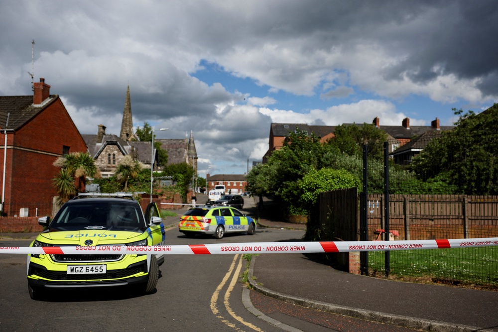 Police vehicles sit near a cordon at the scene of a stabbing outside apartments in the Kinnaird Avenue area of north Belfast (Reuters)