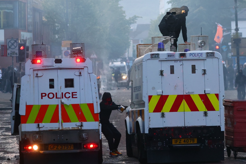 Police vehicles come under attack from protesters late on Tuesday (AP)