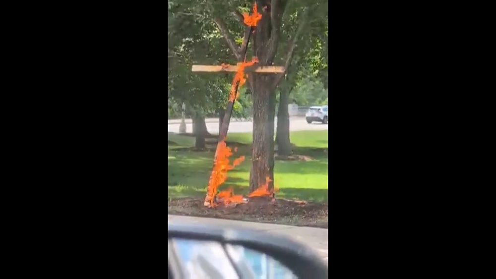 A wooden cross is seen engulfed in flames in Grant Park in Chicago on Tuesday, July 9, 2026 (Keinika Carlton via AP)