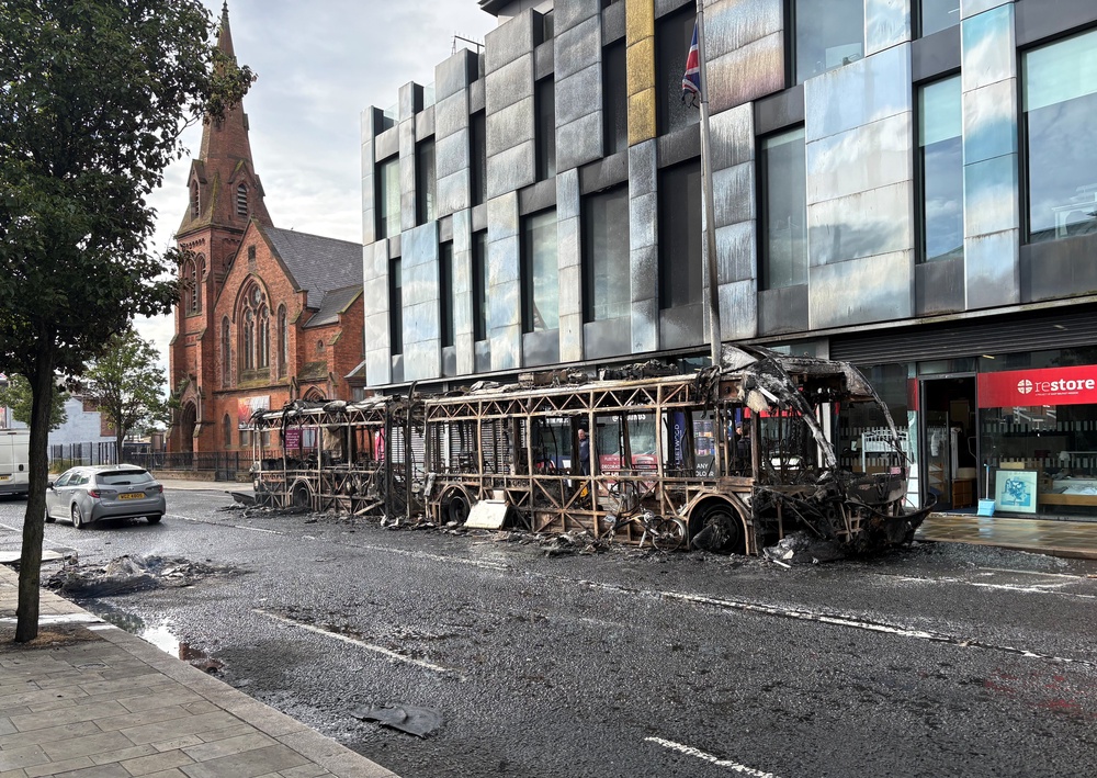 A burned out Gilder bus on Newtownards Road in east Belfast after violence erupted on Tuesday night (PA)