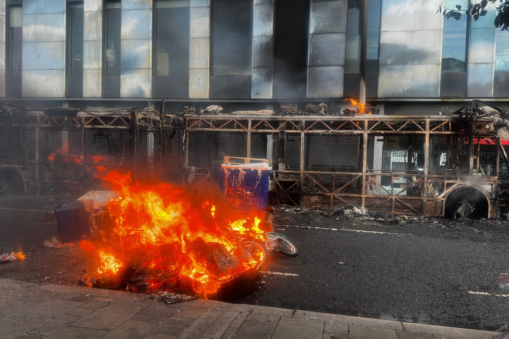 The skeleton of a Glider bus, set on fire by protesters, on the Newtownards Road in east Belfast (PA)
