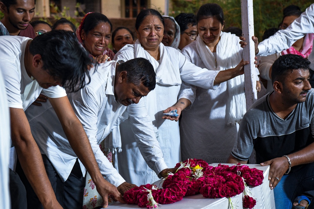 Relatives grieve over Rozar David Christian and his wife Rachnaben Rozar Christian, both victims of the Air India crash, during their funeral in Ahmedabad (AFP/Getty)