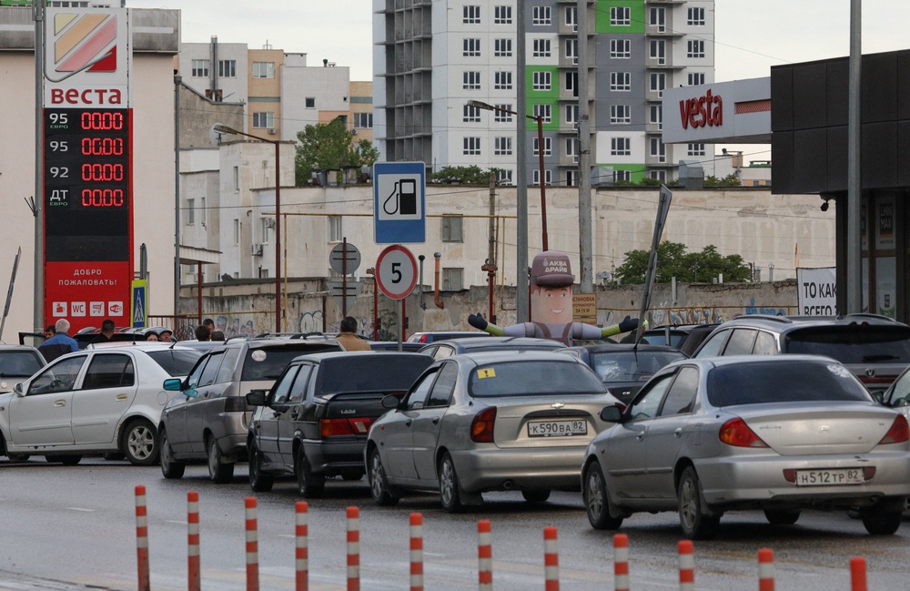 Cars queue for fuel at a gas station after the authorities restricted fuel sales amid a supply shortage in the Black Sea resort city of Yevpatoriya (Reuters)