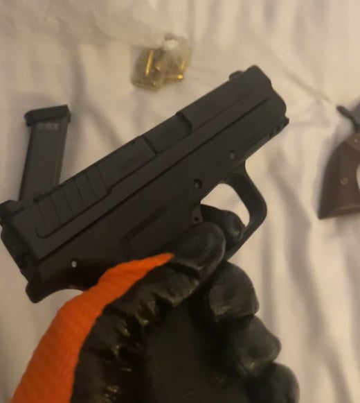 This video grab image of Johannes Natland wearing gloves while handling a gun was shown to the jury (Metropolitan Police)