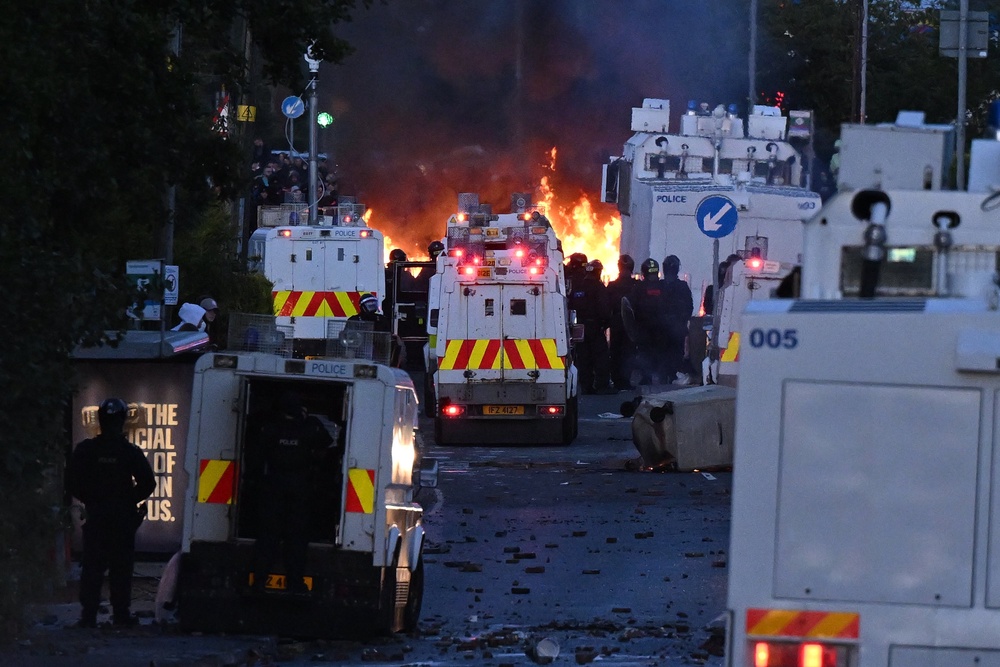 Fire burns near police vans as protests take place near the Chimney Corner Hotel (Getty)