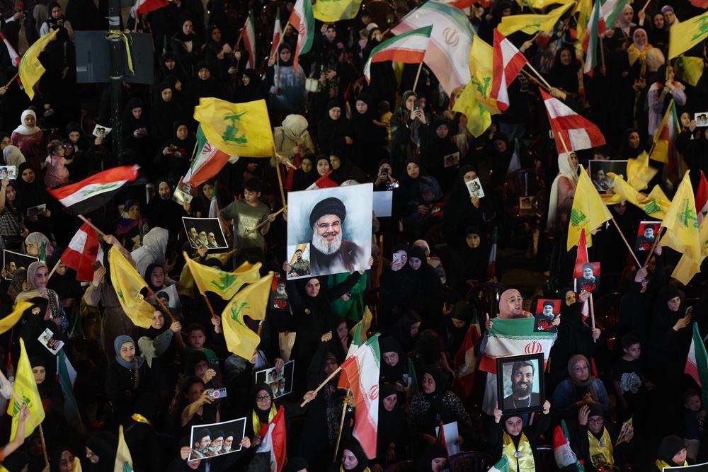 Supporters of Iran-backed armed group Hezbollah, wave flags and hold a portrait of slain leader Hassan Nasrallah during an anti-US and anti-Israel protest organised by the International Popular Committees to Resist Aggression in Beirut's southern suburbs on June 10, 2026 (AFP/Getty)
