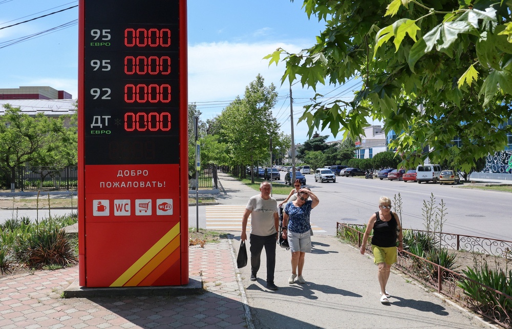 Pedestrians walk past a closed fuel station after local authorities restricted petrol sales and introduced rationing amid a supply shortage in the Black Sea resort city of Yevpatoriya, Crimea (Reuters)