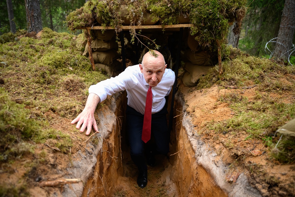 John Healey emerges from a trench after being shown around as British personnel participate in Exercise Spring Storm on 21 May 2026 (Getty)